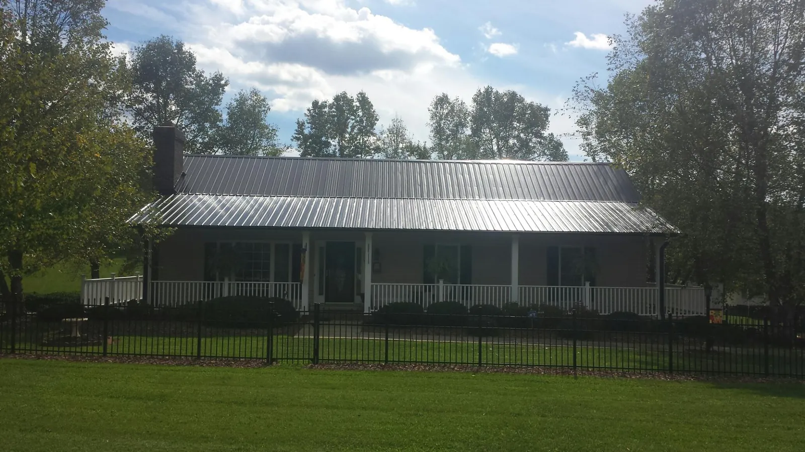 Gray metal roof on a brick ranch with a full width front porch — Gutter Guard Installation work by our crew in Soquel
